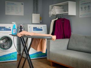 a laundry room with a washing machine and a chair at ibis budget Maceió Pajuçara in Maceió +86 photos