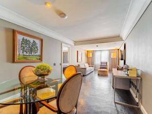 een woonkamer met een glazen tafel en stoelen bij Grand Mercure Curitiba Rayon in Curitiba +271 foto's