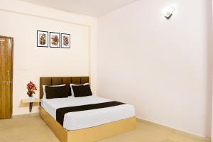 Un dormitorio con una cama en una habitación blanca. en Hotel O Agrawal Inn, en Jabalpur