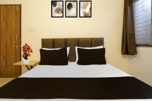 1 dormitorio con 1 cama grande con almohadas negras en Hotel O Agrawal Inn, en Jabalpur 22 fotos más