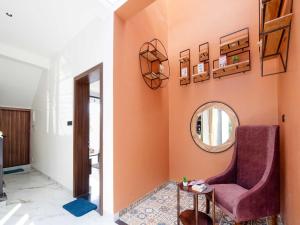 uma sala de estar com uma cadeira e um espelho em Villa Papillon by DanCenter | Pvt Pool | Jacuzzi | Kids Room | Udaipur em Thūr