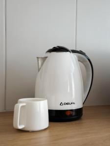 une bouilloire et une tasse sur une table dans l'établissement Поділля, à Netishyn 10 autres photos