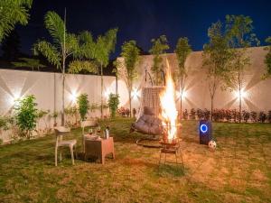 uma fogueira no meio de um quintal à noite em Villa Papillon by DanCenter | Pvt Pool | Jacuzzi | Kids Room | Udaipur em Thūr