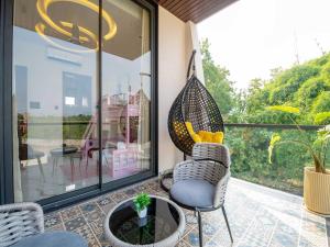 um pátio com uma cadeira e um vaso de plantas em Villa Papillon by DanCenter | Pvt Pool | Jacuzzi | Kids Room | Udaipur em Thūr