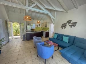 a living room with blue couches and a kitchen at GPSA82 - 4 pax in Fouché