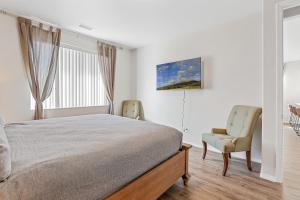 BellemontにあるBeautiful Newly Built Home with Central ACのベッドと椅子と窓のある寝室