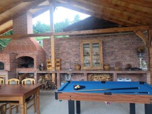 a pool table in front of a brick oven at Cazare La Cetate in Moşna