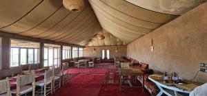 姆哈米德Stars camp的一间带桌椅和天花板的用餐室