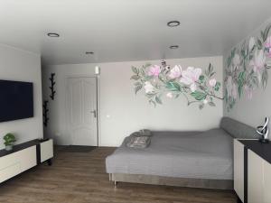 a bedroom with a bed and a flat screen tv at JK apartment in Rēzekne +5 photos