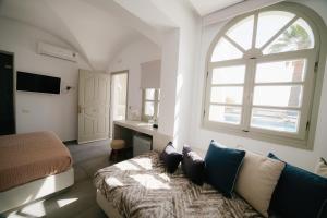 a person laying on a couch in a living room at my life suites in Fira