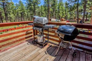 a grill and smoker on a wooden deck at Gorgeous Historic 3 BR Log Cabin w Forest Views 20 Minutes from Flagstaff Now with Wi-Fi in Parks