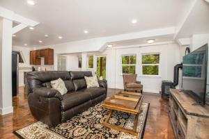 a living room with a leather couch and a table at Captivating 1 BR Chalet Hideaway Prime Location in Mountainaire