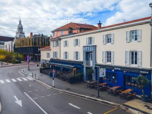 ブール・ガン・ブレスにあるHopperの通りの前にテーブルとベンチがある建物