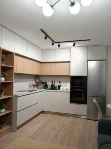 a kitchen with white cabinets and black appliances at Zen aeroport confort in Sînnicoară