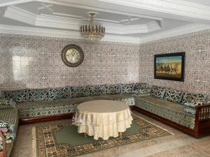 Una sala de estar con un sofá y un reloj en la pared. en Tradition & Modernité, en Rabat
