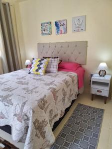 a bedroom with a large bed with pink sheets at Aconchego do Amor com Suíte com piscina in Pelotas