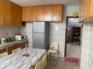 Una cocina con una mesa con sillas y un refrigerador. en Tradition & Modernité, en Rabat