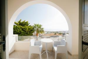 a room with a table and chairs and a window at my life suites in Fira