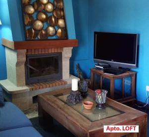 a living room with a fireplace and a tv at Casa Tictágora in Plasenzuela