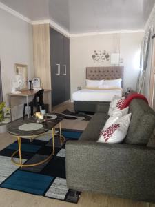 a living room with a couch and a bed at The Converted Space in Welkom