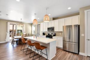 弗拉格斯塔夫Windtree Retreat Hot Tub Pet-Friendly Fire Pit Near Downtown的厨房配有白色橱柜和桌子及椅子