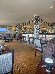 a restaurant with tables and chairs and a bar at The Wee Sprout in Stranraer