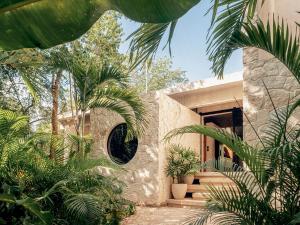 a stone house with a round window and palm trees at Casa M in Macario Gomez