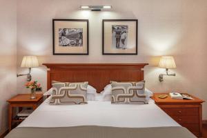 1 dormitorio con 1 cama grande y 3 cuadros en la pared en Starhotels Metropole, en Roma