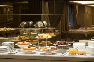 a buffet line with various pastries and desserts on plates at Starhotels Michelangelo Florence in Florence