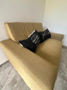 a brown couch with two black pillows on it at Nexo departamentos in San José
