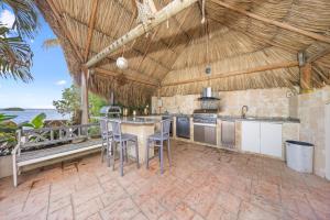 an outdoor kitchen with a table and chairs in a building at Private Beach Ocean Front Boat Dock Tiki Bar in Savaneta