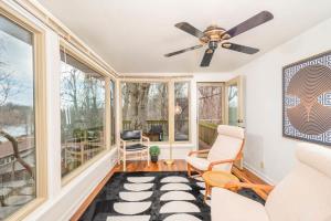 a living room with a ceiling fan and windows at Private Riverside Retreat in Appleton