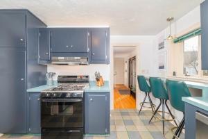 a kitchen with blue cabinets and a stove at Private Riverside Retreat in Appleton