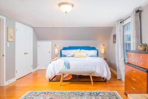 Schlafzimmer mit blauem Bett und Holzboden in der Unterkunft Outstanding 4 Bedroom on Outagamie in Appleton