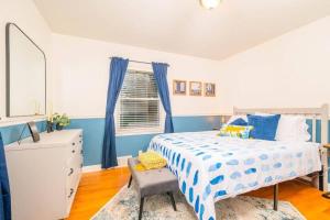 ein Schlafzimmer mit einem Bett, einer Kommode und einem Fenster in der Unterkunft Outstanding 4 Bedroom on Outagamie in Appleton