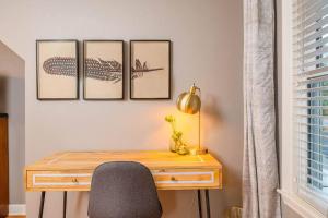 Ein Schreibtisch mit Stuhl und vier Bildern an der Wand in der Unterkunft Outstanding 4 Bedroom on Outagamie in Appleton