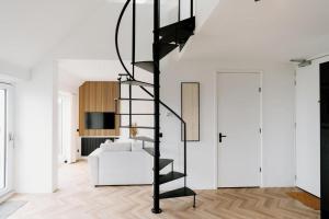 OffingawierにあるLake House 10 - 4 Person Lake view apartment!の白いソファのあるリビングルームの黒い螺旋階段
