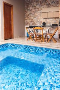 a pool with a table and chairs in a house at Casa Acqua Beach in Vilhena