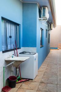 a washing machine in a room with a blue wall at Casa Acqua Beach in Vilhena