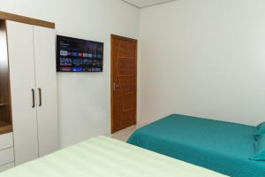a bedroom with a bed and a tv on the wall at Casa Acqua Beach in Vilhena +8 photos