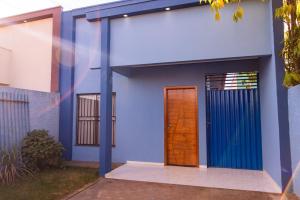 a blue house with a wooden door at Casa Acqua Beach in Vilhena