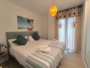 une chambre avec deux lits et une grande fenêtre dans l'établissement Loredo Beach 1, à Loredo 38 autres photos