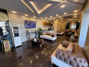 a living room with couches and a clock on the wall at Al-Farouq Suites in Amman