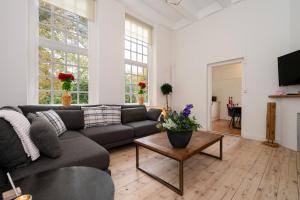 una sala de estar con un sofá y una mesa en De Zwaluwenburg, en 't Harde