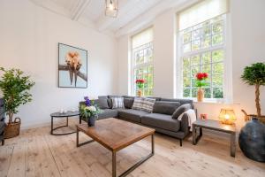 una sala de estar con un sofá y una mesa en De Zwaluwenburg, en 't Harde