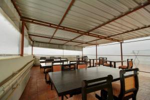 a group of tables and chairs in a room at Hotel O Manu Residency in Bangalore