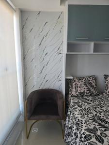 a small bedroom with a bed and a chair at Full studio, TV, washing machine, microwave in Sao Paulo +1 photo