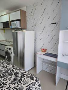 a small kitchen with a refrigerator and a counter at Full studio, TV, washing machine, microwave in Sao Paulo