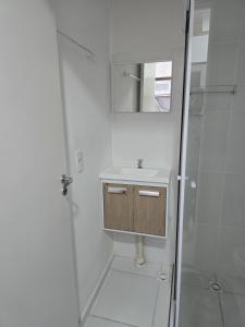a white bathroom with a sink and a shower at Full studio, TV, washing machine, microwave in Sao Paulo