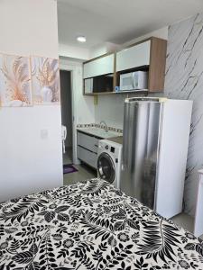 a kitchen with a refrigerator and a washing machine at Full studio, TV, washing machine, microwave in Sao Paulo